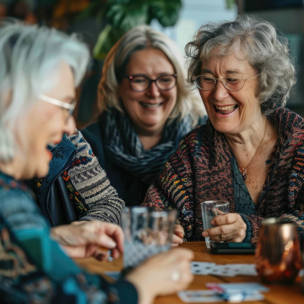 Baxter Senior Living | joyful group of seniors playing cards and sharing laughter