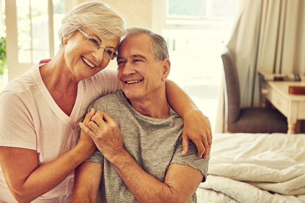 senior Couple embracing and smiling, exploring senior living options