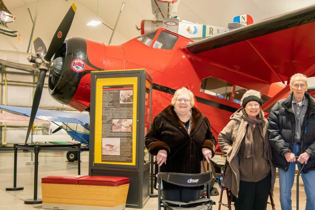 Baxter Senior Living | Assisted living residents in alaska standing in front of a plane