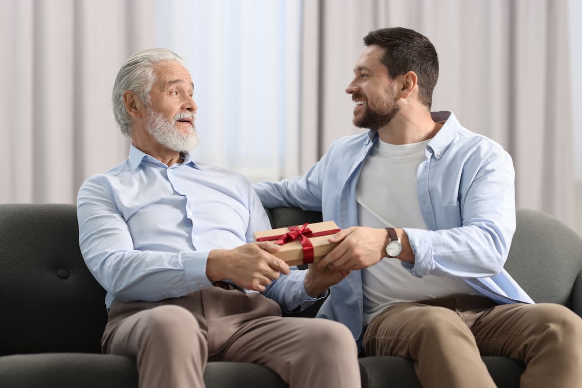 Baxter Senior Living | Senior receiving a gift from his son